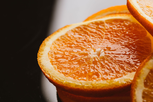 sliced orange halves on a dark background closeup - Фото, изображение