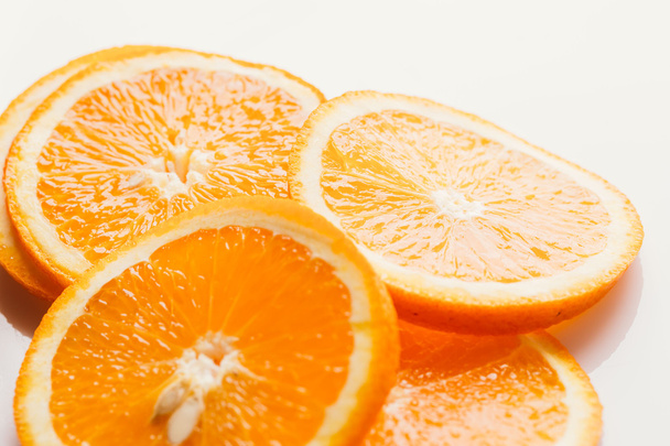 sliced orange circles on a light white background closeup - Zdjęcie, obraz