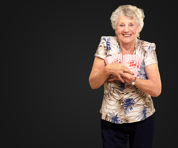 Ritratto di una donna anziana che tiene una scatola di popcorn
 - Foto, immagini