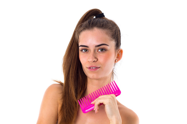 Young woman holding pink hair brush - Fotó, kép