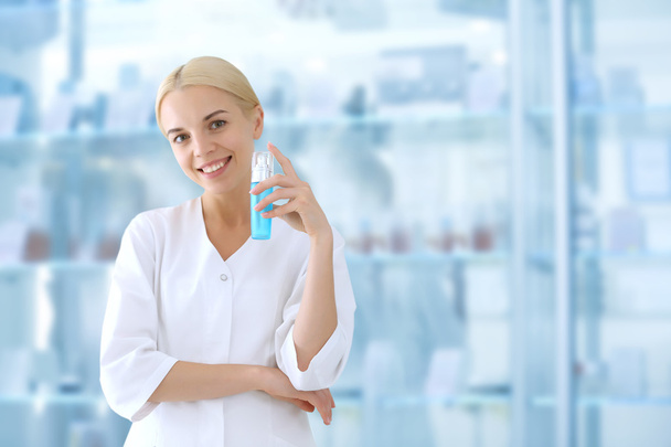 Cosmetologist holding cream beside showcases - Foto, Imagem
