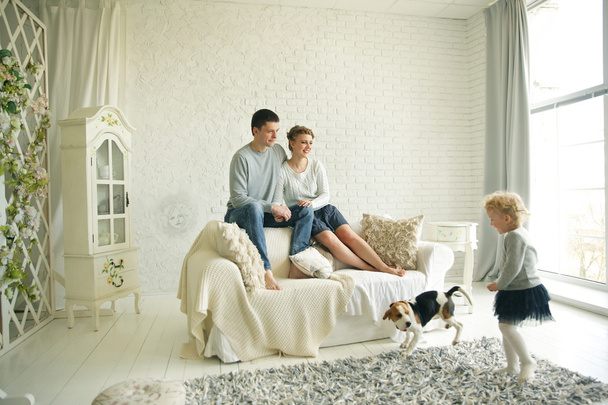 Happy family with pet in bright living room - Φωτογραφία, εικόνα