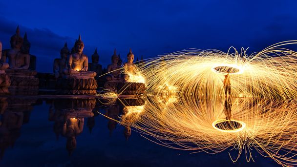 Silhouette Buddha. Fin del concepto del Día de Cuaresma Budista y Duchas de chispas brillantes calientes de lana de acero giratoria, Thung Yai, Nakhon Si Thammarat, Tailandia
 - Foto, imagen