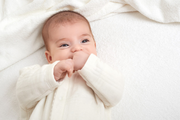 Babyportait liegt auf weißem Handtuch im Bett - Foto, Bild