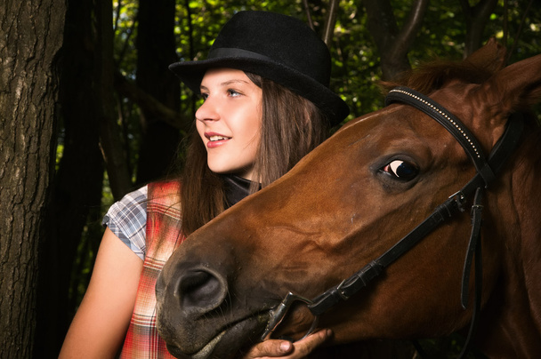 Cowgirl in hat with bay horse - Foto, imagen