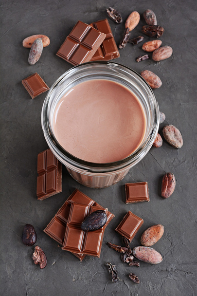 Chocolate milk and pieces of chocolate bar and cocoa beans - Zdjęcie, obraz