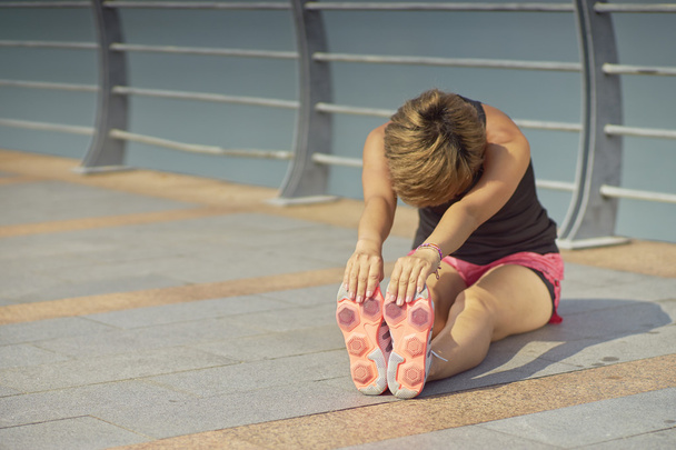young Asian woman stretching legs before jogging - Photo, Image