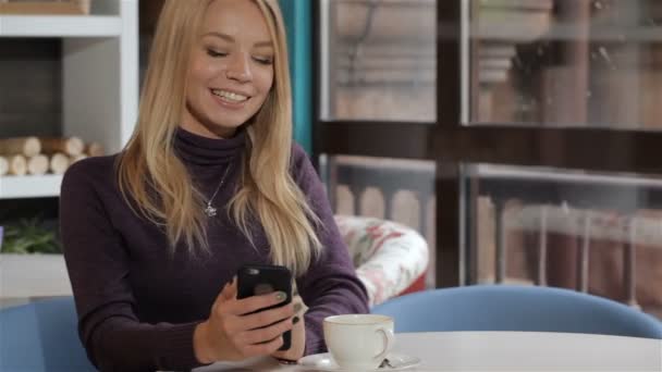 Жінка повідомлення по її мобільному телефону в кафе
 - Кадри, відео