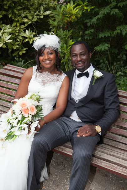 Jeune couple afro-américain nouvellement marié sur un banc
 - Photo, image
