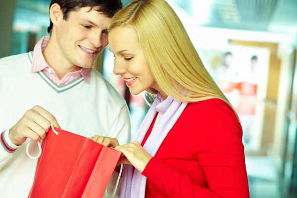 Young couple looking into shopping bag.   - Photo, Image