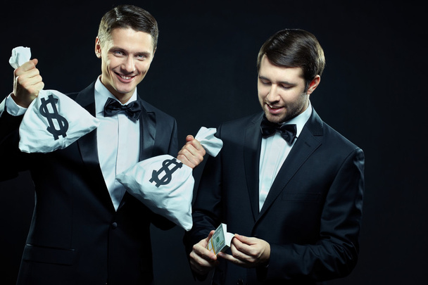 Dwóch mężczyzn uśmiechający się liczenie dolarów - Zdjęcie, obraz