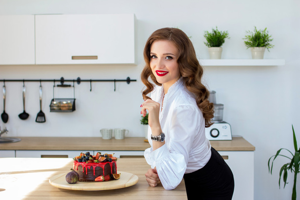the beautiful woman has made cake in kitchen - Foto, afbeelding