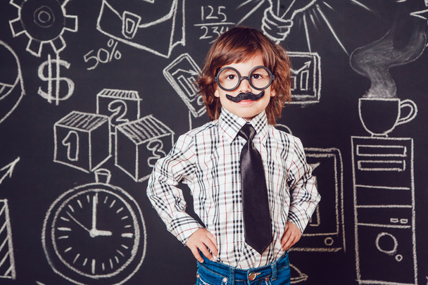 Mały chłopiec jako biznesmen lub nauczyciel z wąsy i okulary stoi na ciemnym tle wzór. Noszenie koszulki, krawat - Zdjęcie, obraz