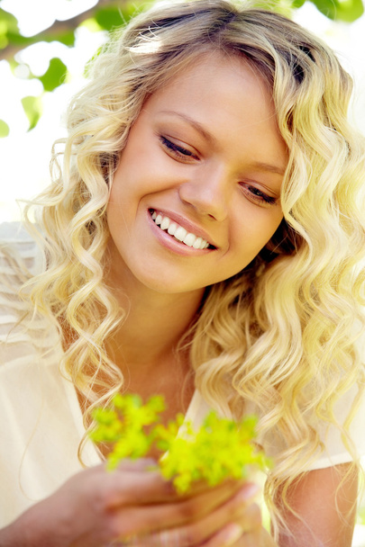 Smiling woman holding leaves - Foto, afbeelding
