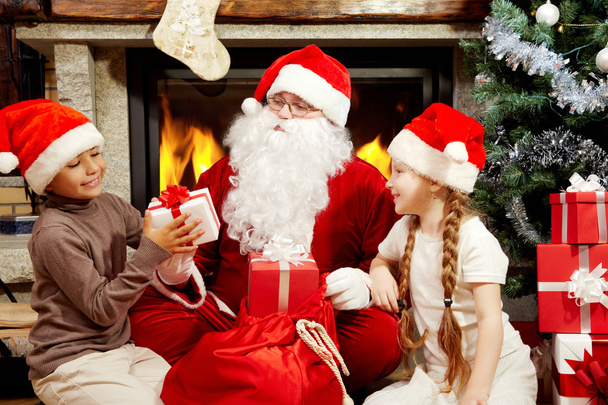 Le Père Noël donne des cadeaux aux enfants
 - Photo, image