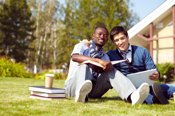 Jovens estudantes do sexo masculino sentados no campus
 - Foto, Imagem