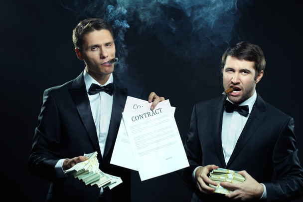 бизнесмены, показывающие контракты и деньги
 - Фото, изображение