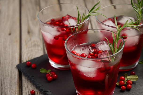 Refreshing drink with cranberries and rosemary on wooden background - Photo, Image