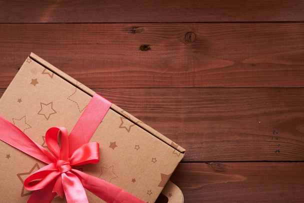 envoltura de regalo con una cinta rosa en una mesa de madera
 - Foto, Imagen