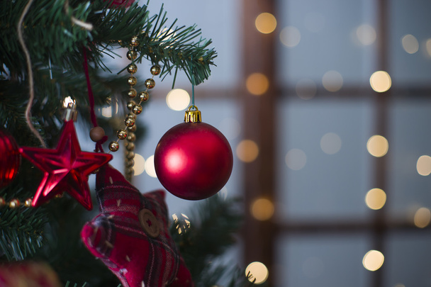 Shiny Christmas red ball hanging on pine branches with festive background - Fotoğraf, Görsel