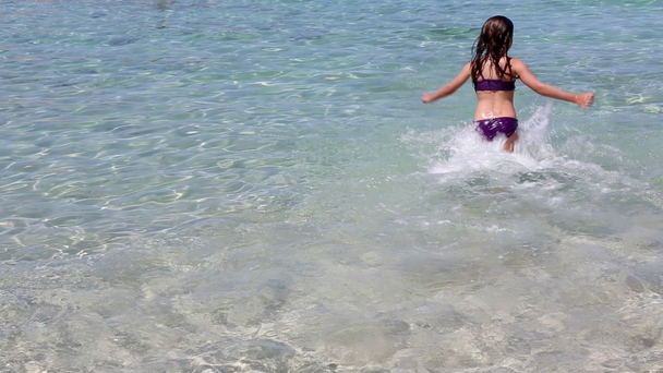 Beautiful little girl playing in ibiza beach on summer vacation - Imágenes, Vídeo