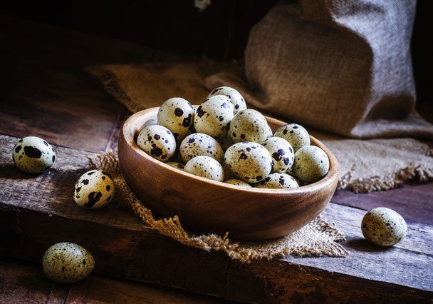 Quail eggs, old wooden background - Foto, afbeelding