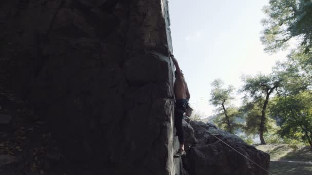 Profi-Kletterer auf Klippe gibt jemandem Anweisungen - Filmmaterial, Video