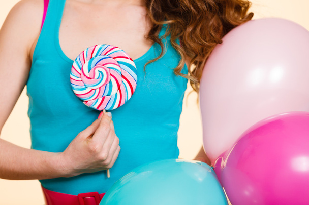 Woman holds colorful balloons and lollipop - Фото, изображение