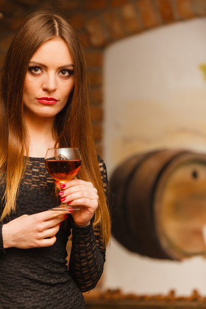 Woman tasting wine in rural cottage interior - Photo, Image