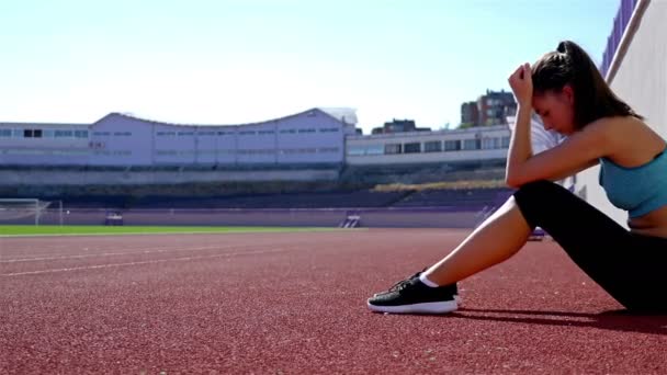 Desperate disappointed track runner athlete woman at a stadium, dolly - Footage, Video