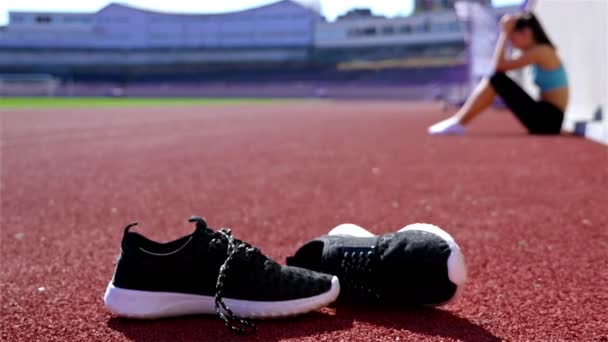 Wanhopig teleurgesteld track runner atleet vrouw bij een stadion, schoenen aan de voorkant, dolly - Video