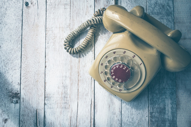 Верхний вид старого телефона на фоне деревянного стола, винтажный тон
 - Фото, изображение