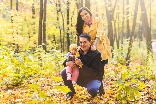 秋の公園での屋外の時間を費やして自分の娘と一緒に幸せな若い家族. - 写真・画像