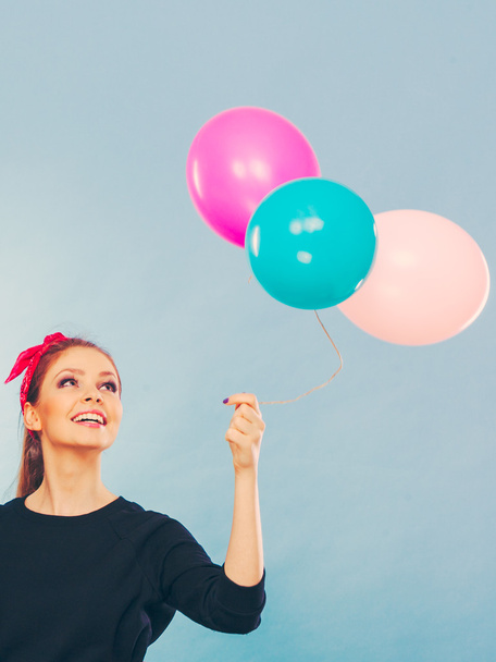Lovely smiling girl holds colorful balloons. - Фото, изображение