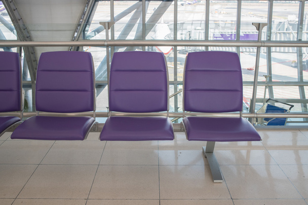 Airport terminal interior with rows of empty seats, city view an - 写真・画像