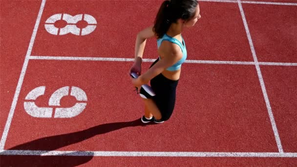 Corredor de pista atleta mujer calentando antes de correr en un estadio, vista superior
 - Metraje, vídeo