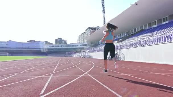 Cámara de seguimiento de una atleta corredor de pista chica corriendo en un estadio
 - Metraje, vídeo