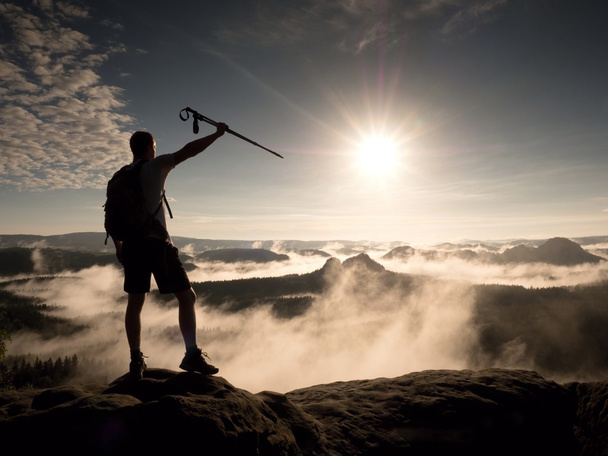Hiker on peak. Tourist with bag in target with trekking poles in hand - Φωτογραφία, εικόνα