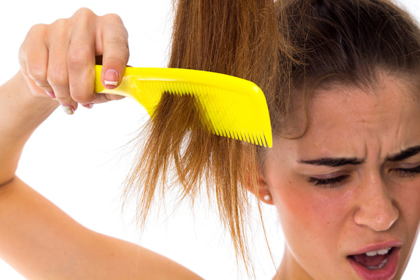 Young woman combing her long ponytail - Φωτογραφία, εικόνα