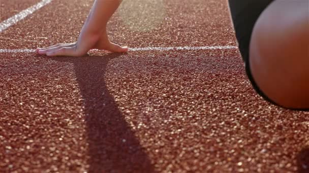Śledzić runner kobieta wprowadzenie jej ręce w linii startowej - Materiał filmowy, wideo