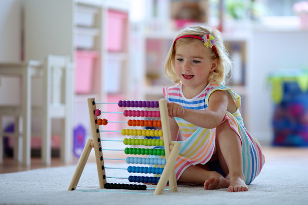 Preschooler girl playing with wooden toy abacus - Fotoğraf, Görsel