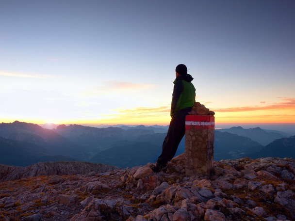 Втомився мандрівного сидіти на кордоні камінь на гори Альп. Австрія Німеччина кордон. Світанку над Туманний Долина - Фото, зображення