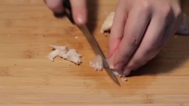 Cutting mushrooms with a knife in kitchen - Filmati, video