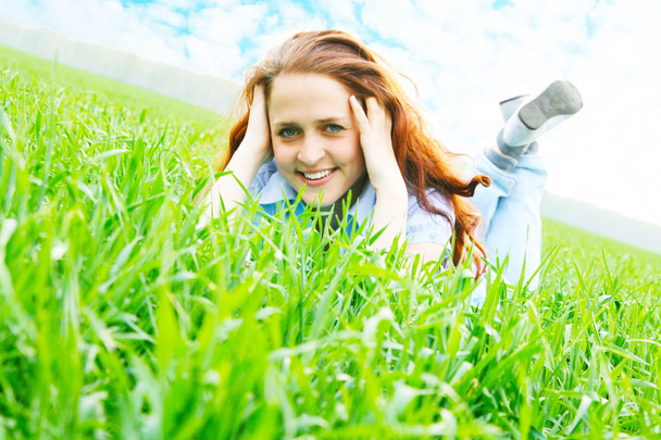 Young beautiful girl dreaming on green field - Фото, зображення