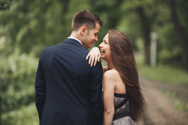 Young beautiful couple, girl with perfect dress posing in park - 写真・画像