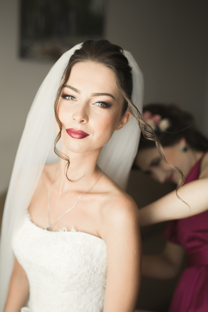 Luxury bride in white dress posing while preparing for the wedding ceremony - Fotoğraf, Görsel
