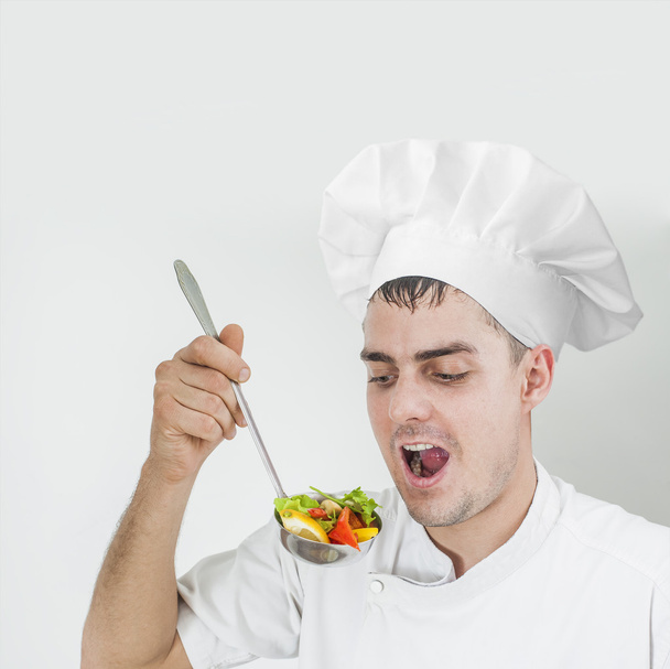 chef  in uniform eating out ladle full slices Vegetarian food - Foto, afbeelding