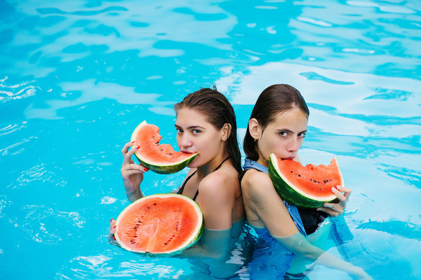 women with watermelon in swimming pool - Zdjęcie, obraz