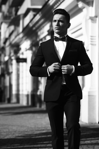 Elegant man unbuttons suit coat - Fotoğraf, Görsel