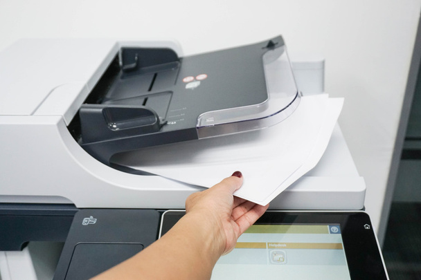 businesswoman pull pieces of paper from printer - Φωτογραφία, εικόνα